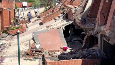 After Colombia earthquake, Cali residents gather around a fire amid the ruins